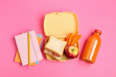 Photo of Lunch box with snacks, bottle of juice and stationery on pink background, flat lay