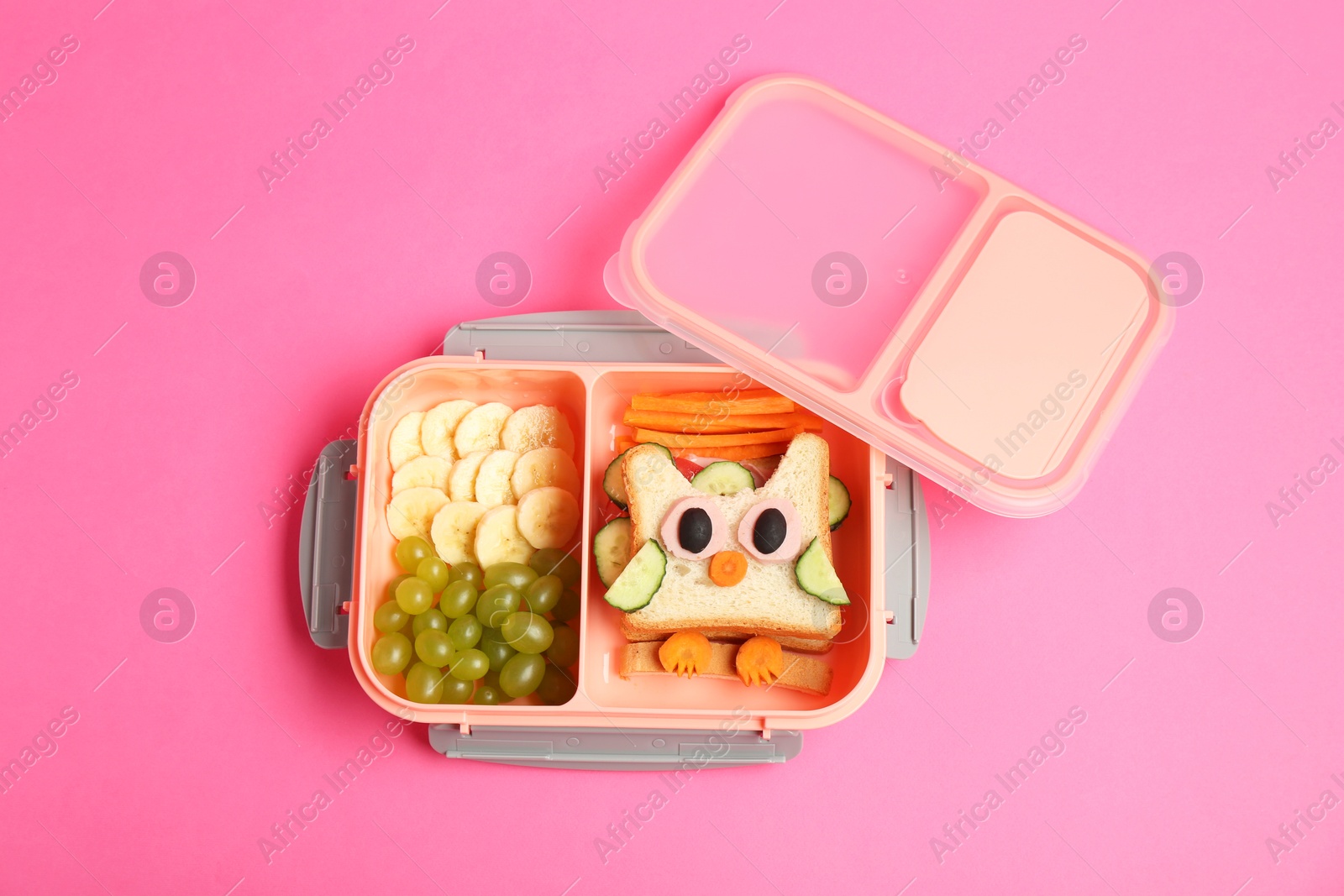 Photo of Lunch box with sandwich and fruits on pink background, top view