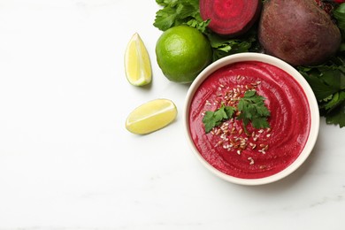 Tasty beetroot hummus in bowl and products on white marble table, flat lay. Space for text