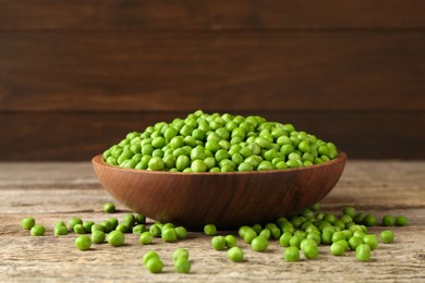 Photo of Fresh green peas in bowl on wooden table