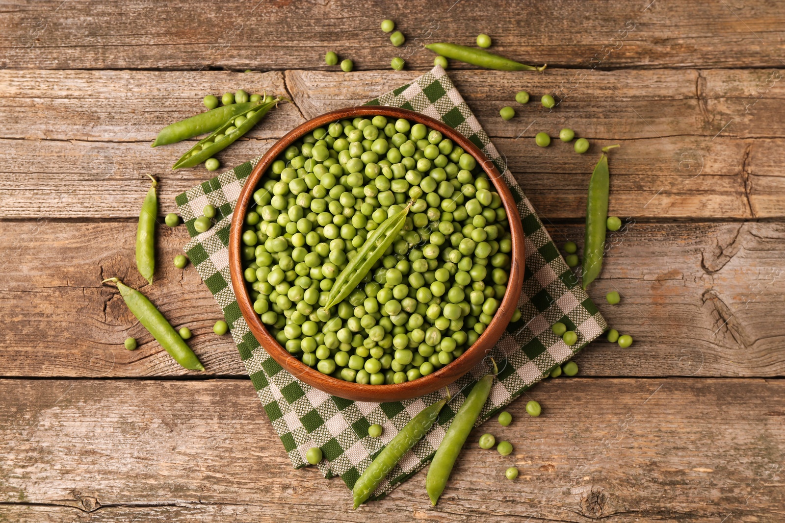 Photo of Fresh green peas and pods on wooden table, flat lay