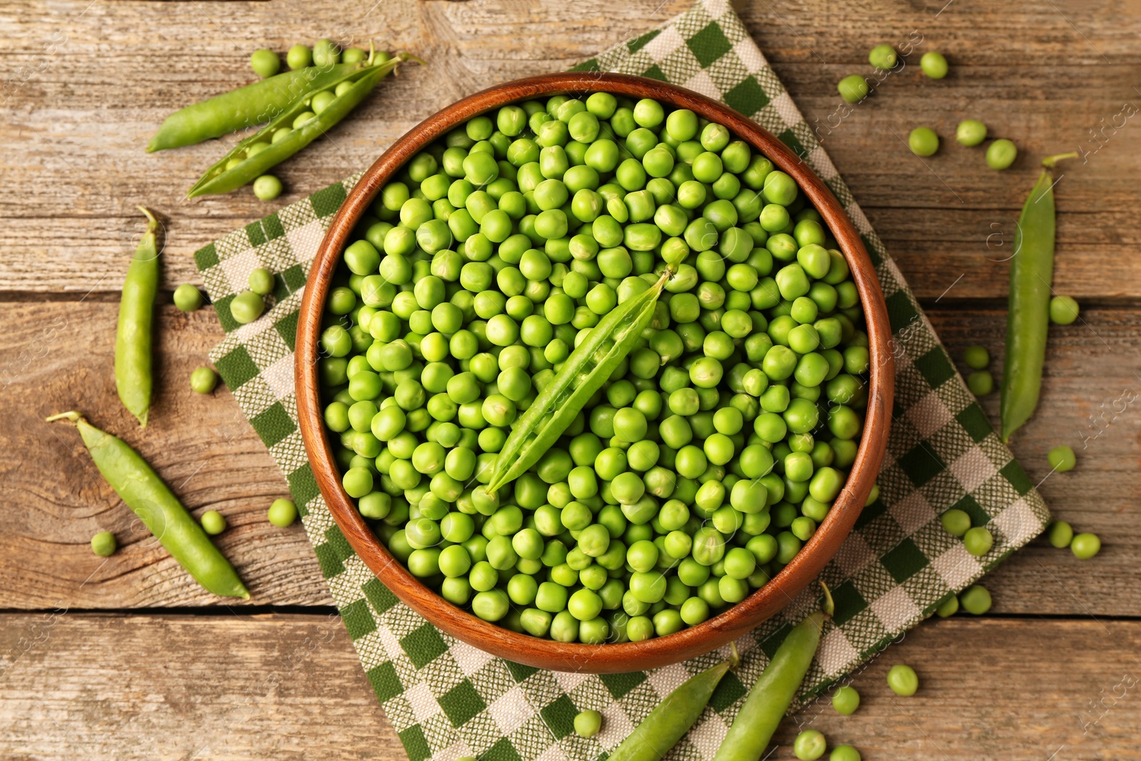 Photo of Fresh green peas and pods on wooden table, flat lay