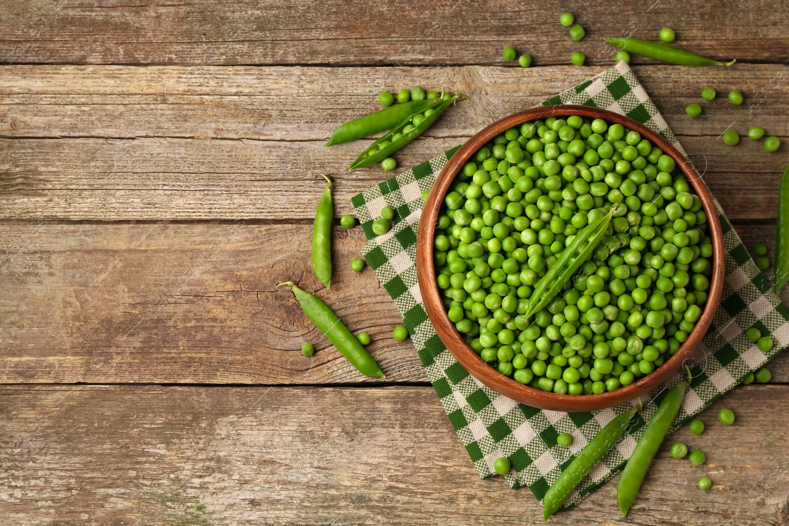 Photo of Fresh green peas and pods on wooden table, flat lay. Space for text