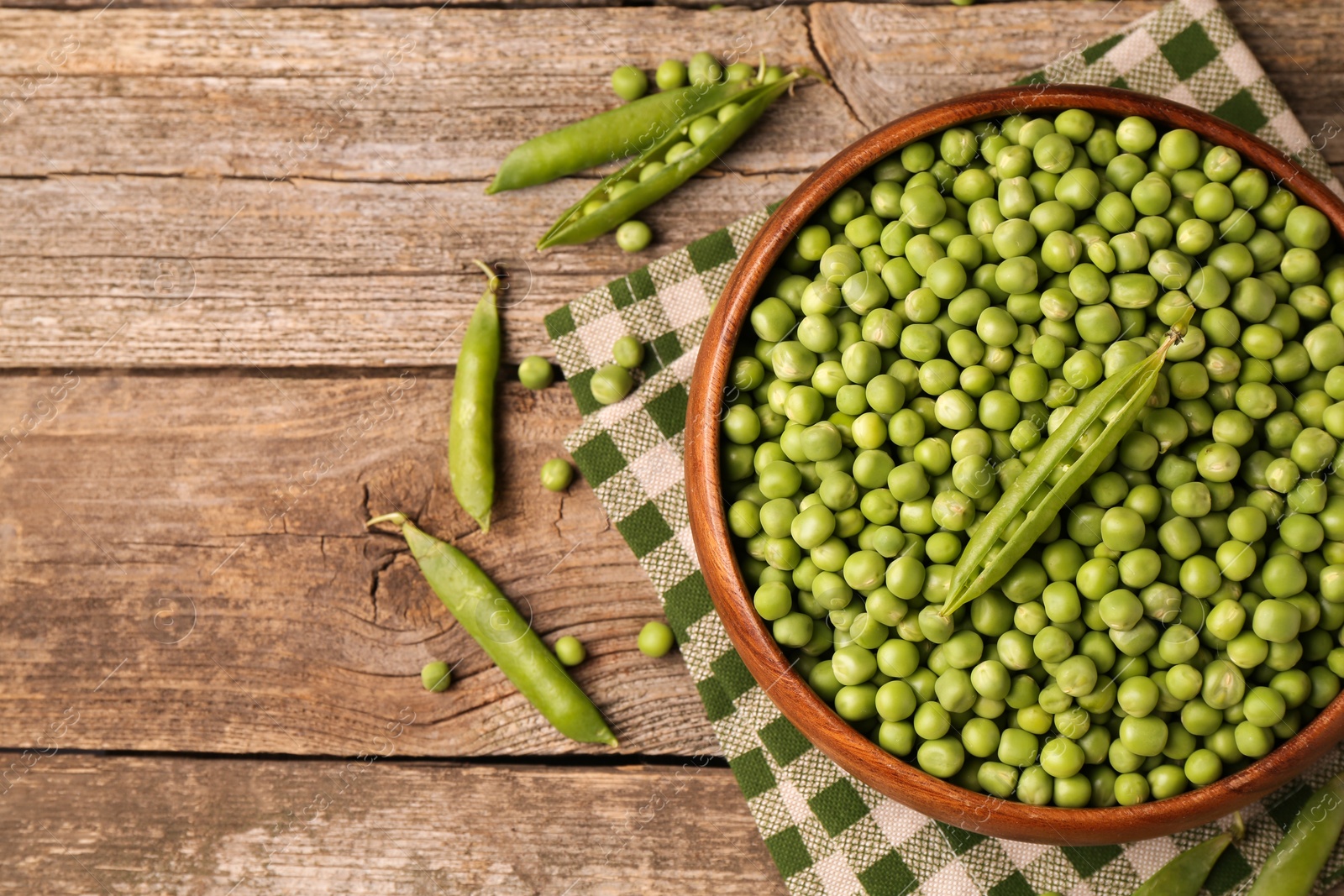 Photo of Fresh green peas and pods on wooden table, flat lay. Space for text