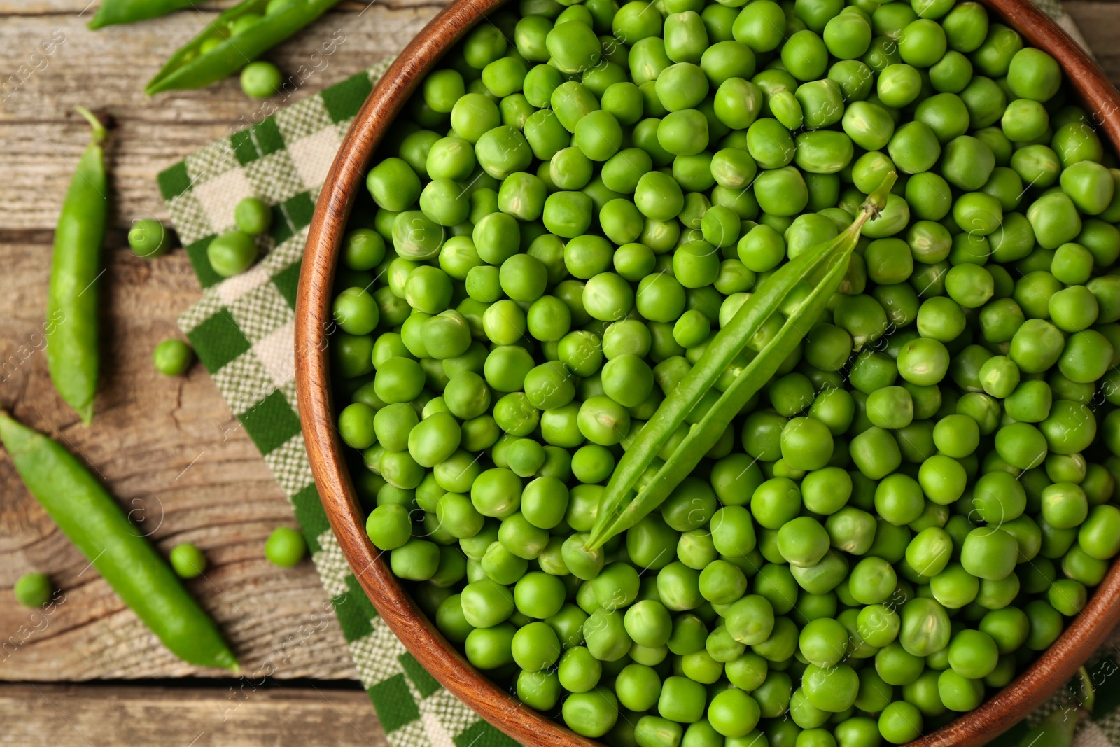 Photo of Fresh green peas and pods on wooden table, flat lay