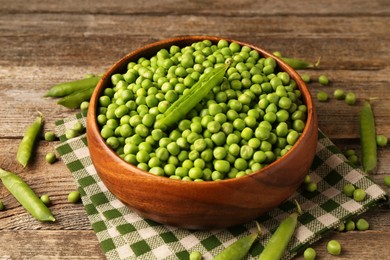 Fresh green peas and pods on wooden table, closeup