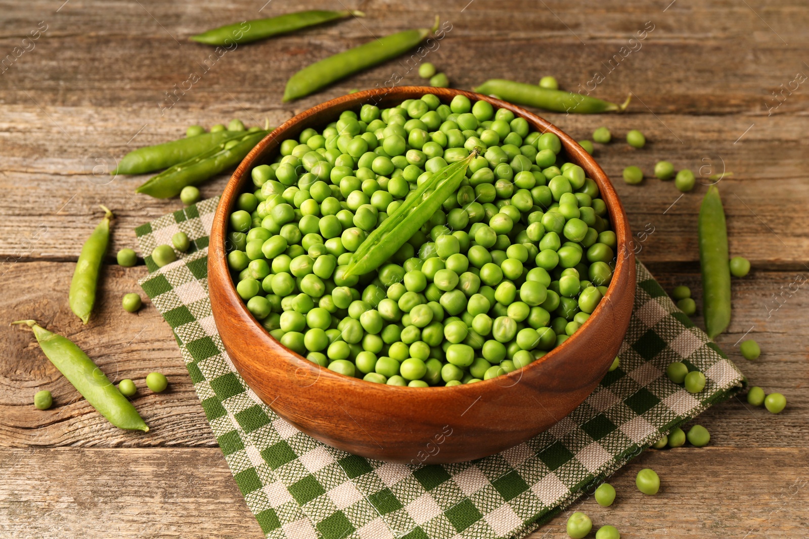 Photo of Fresh green peas and pods on wooden table