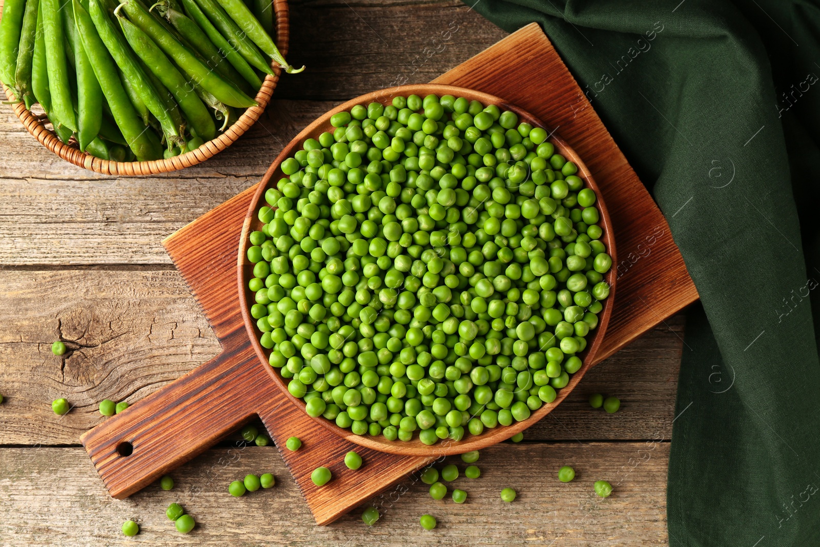 Photo of Fresh green peas and pods on wooden table, flat lay