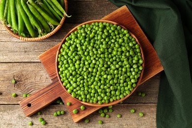 Photo of Fresh green peas and pods on wooden table, flat lay