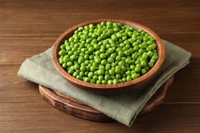 Photo of Fresh green peas in bowl on wooden table