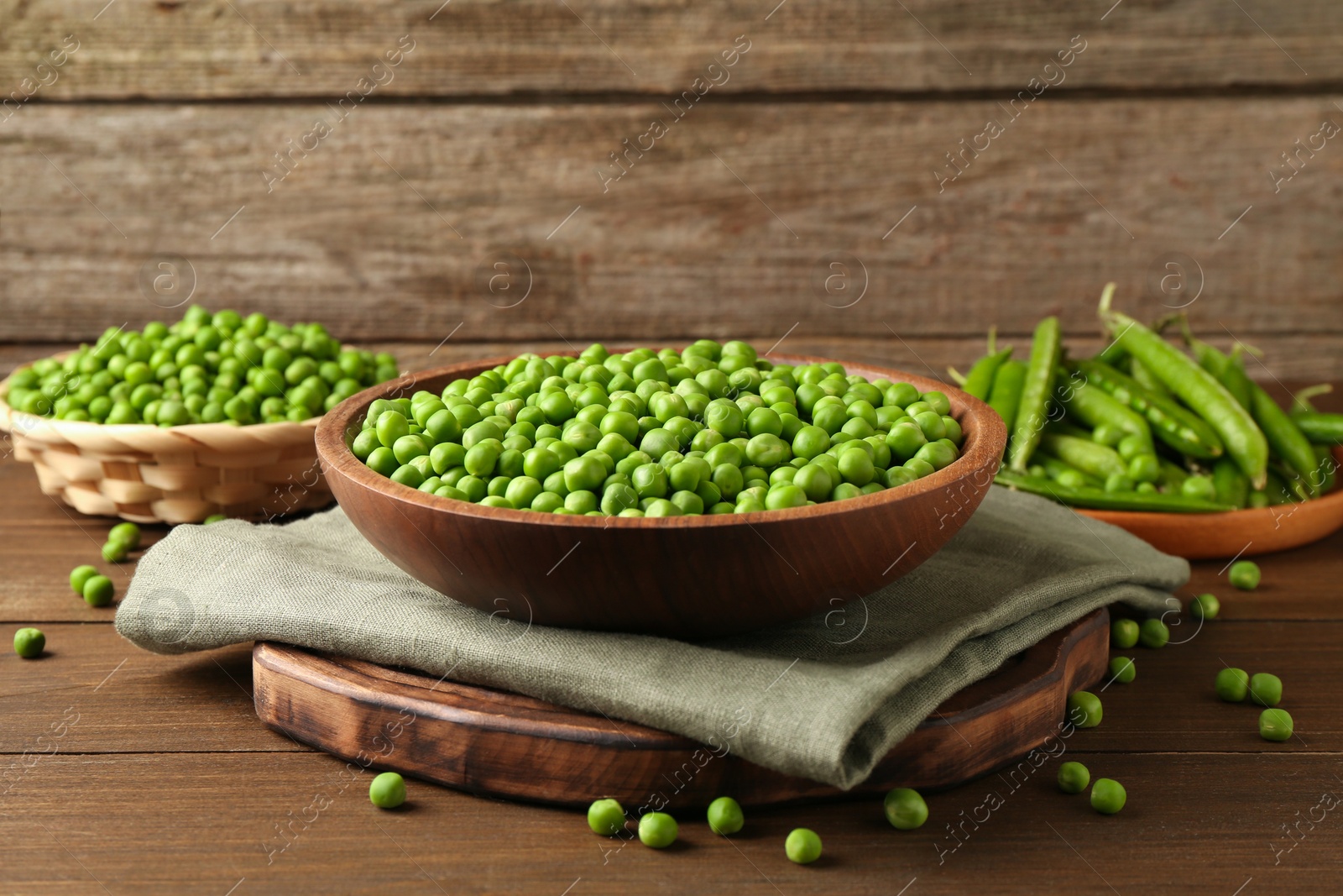 Photo of Fresh green peas and pods on wooden table