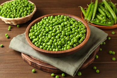 Photo of Fresh green peas and pods on wooden table