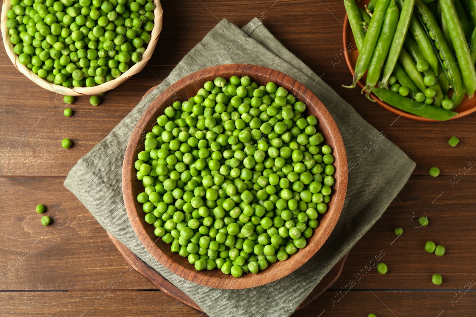 Photo of Fresh green peas and pods on wooden table, flat lay