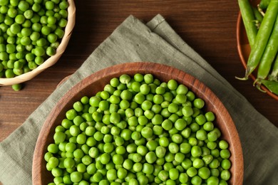 Photo of Fresh green peas and pods on wooden table, flat lay