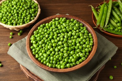 Photo of Fresh green peas and pods on wooden table