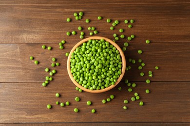 Photo of Fresh green peas in bowl on wooden table, top view