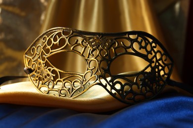 One beautiful carnival mask on golden fabric, closeup