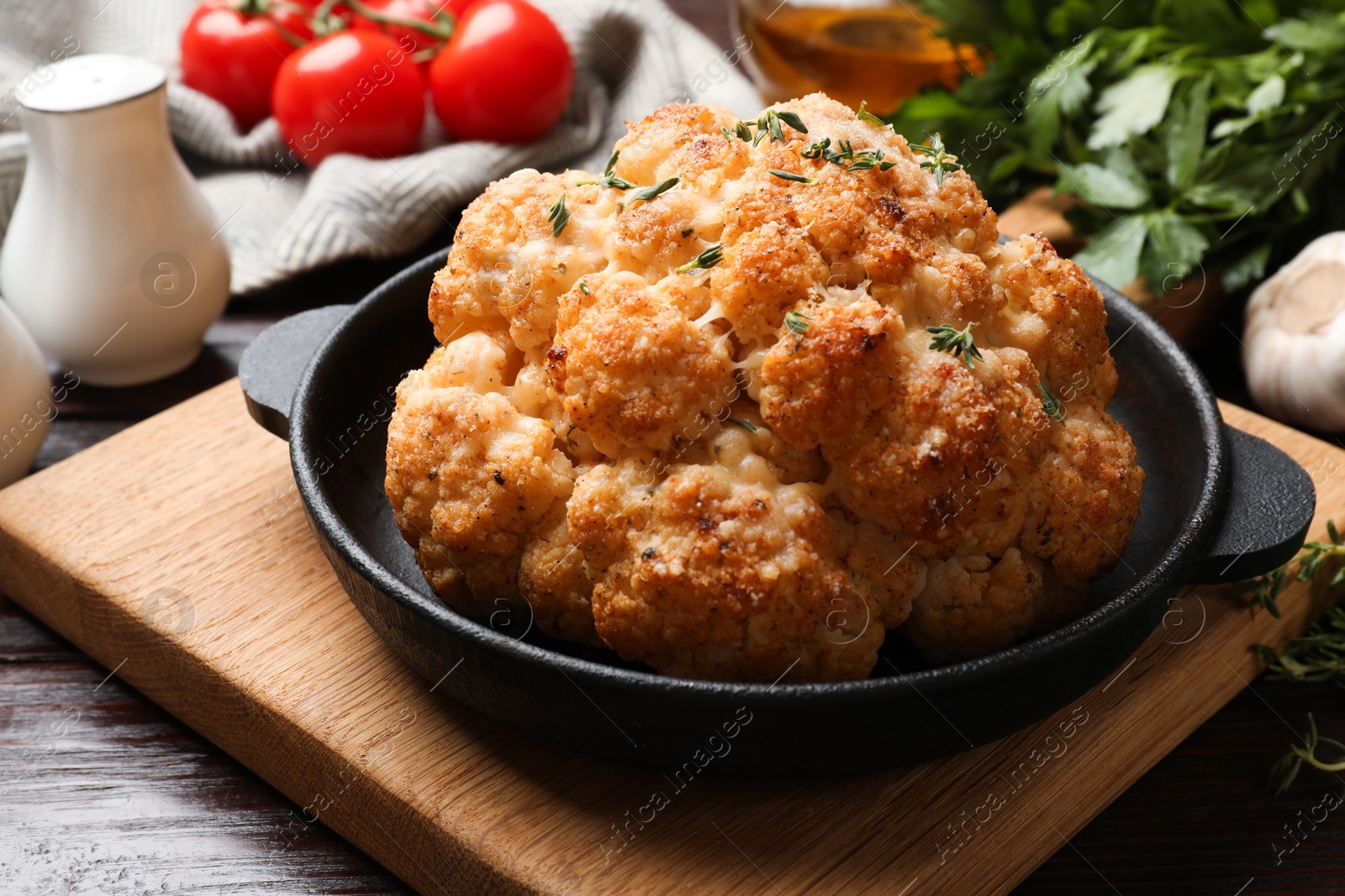 Photo of Delicious baked cauliflower in baking dish on wooden table, closeup