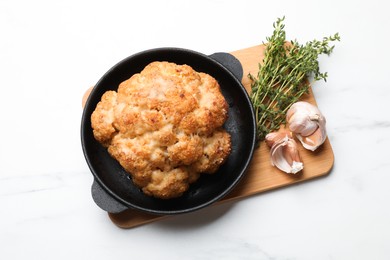 Delicious baked cauliflower in baking dish and spices on white table, top view