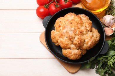 Photo of Delicious baked cauliflower, tomatoes and spices on wooden table, flat lay. Space for text