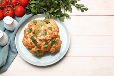 Photo of Delicious baked cauliflower, tomatoes and spices on wooden table, flat lay. Space for text