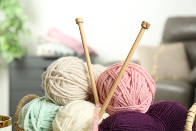 Photo of Colorful yarns and knitting needles on blurred background, closeup