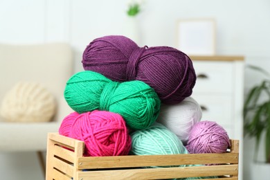 Photo of Wooden crate with different yarns on blurred background