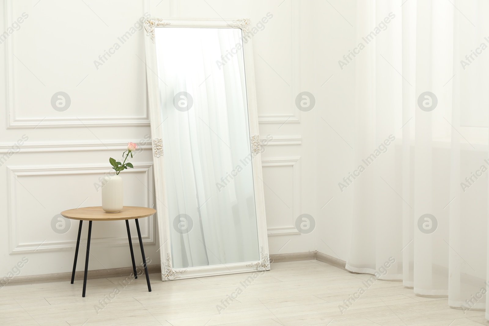 Photo of Large mirror near white wall in room. Interior design