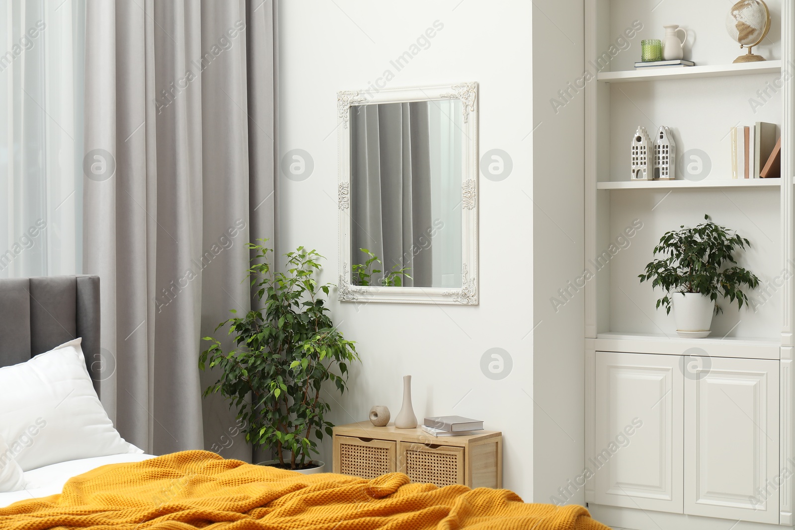 Photo of Mirror on white wall in bedroom. Interior design