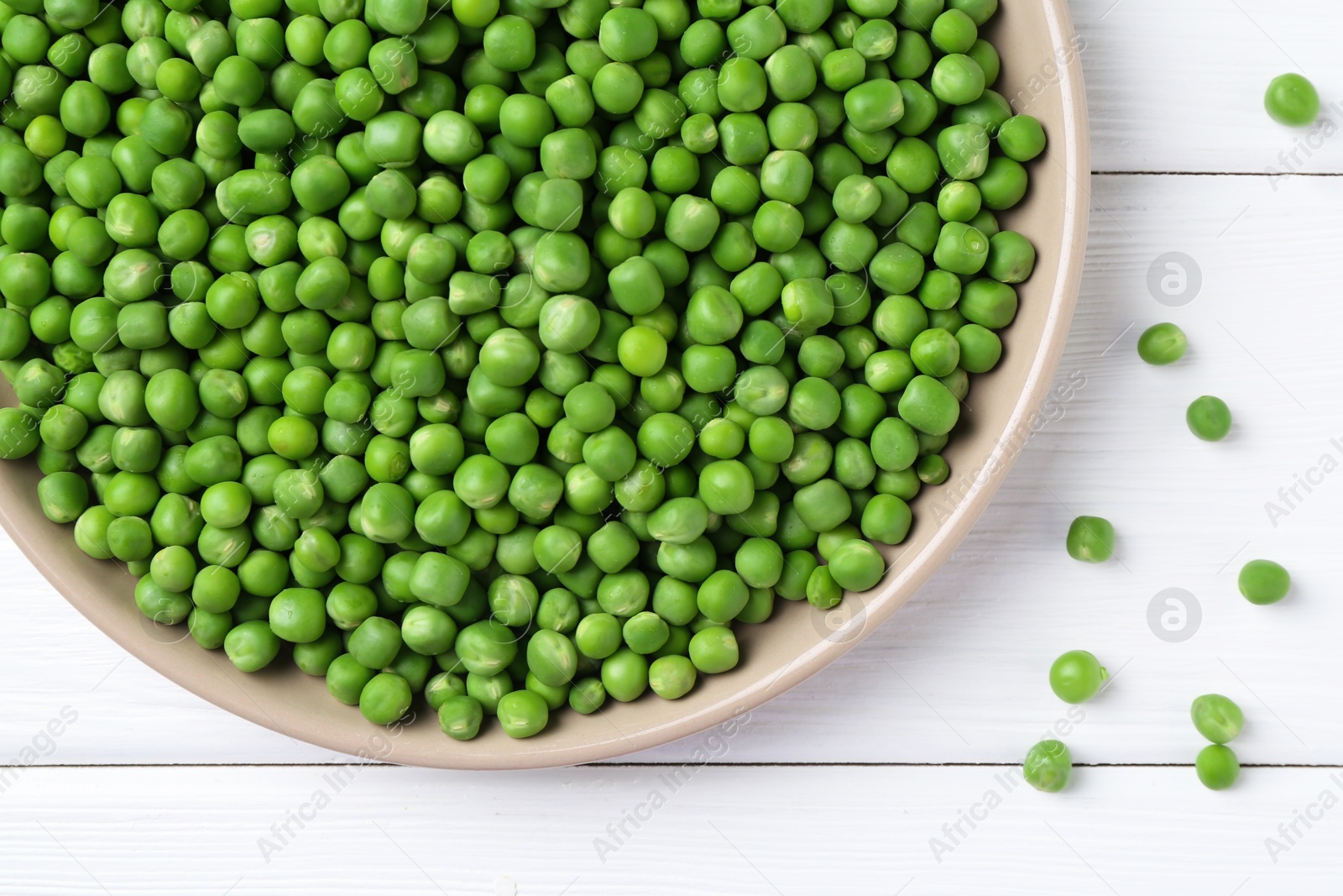 Photo of Fresh green peas on white wooden table, top view