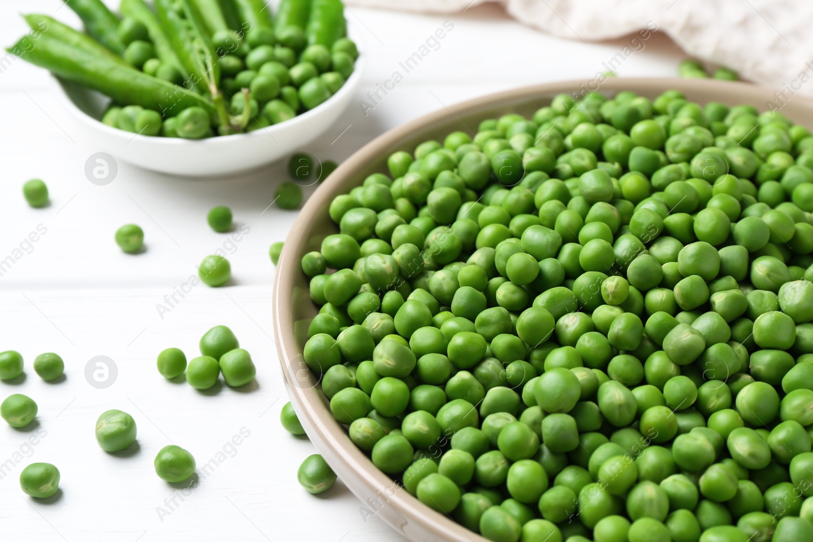 Photo of Fresh green peas and pods on white wooden table, closeup