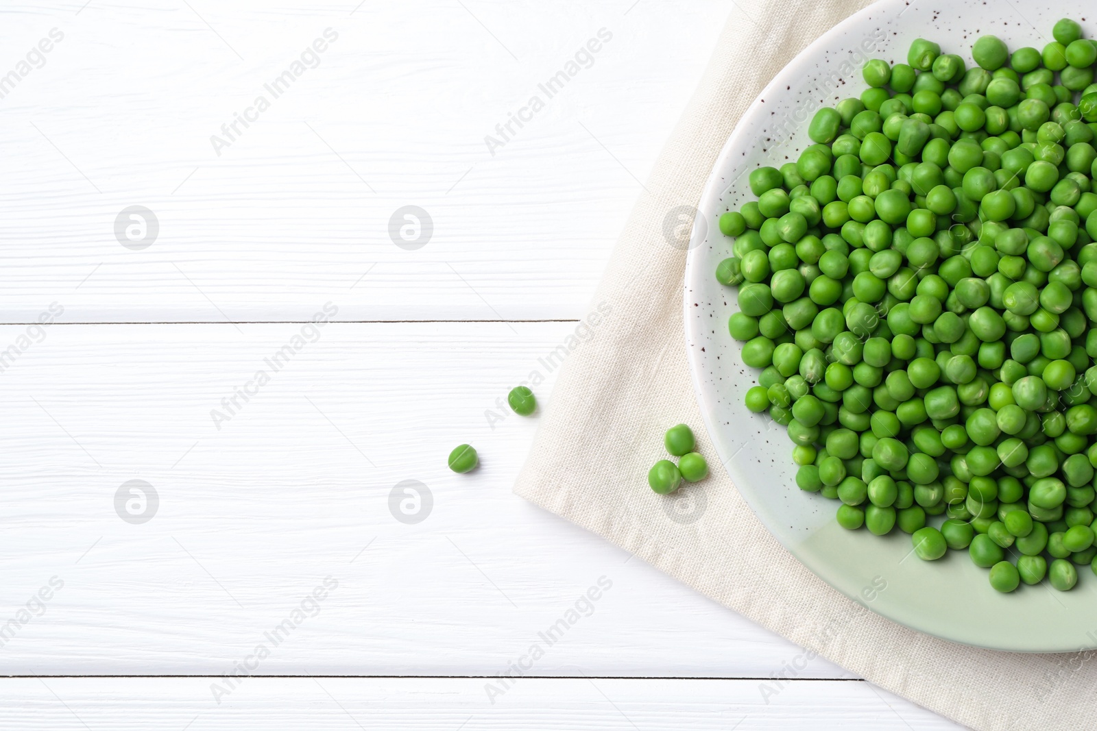 Photo of Fresh green peas on white wooden table, top view. Space for text