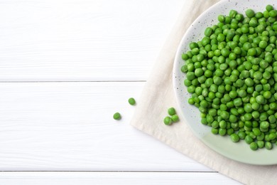 Photo of Fresh green peas on white wooden table, top view. Space for text