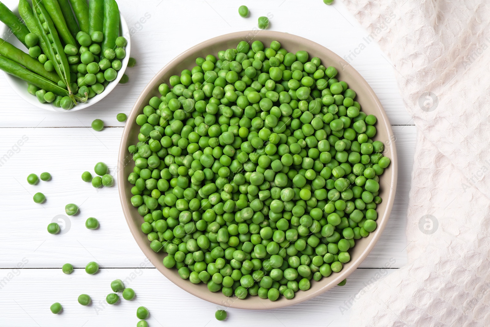 Photo of Fresh green peas and pods on white wooden table, flat lay