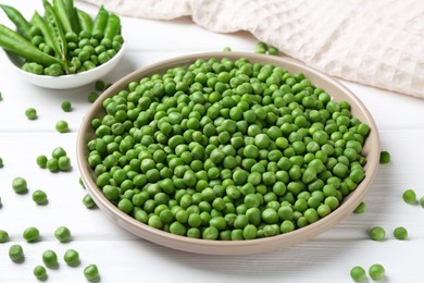 Photo of Fresh green peas and pods on white wooden table