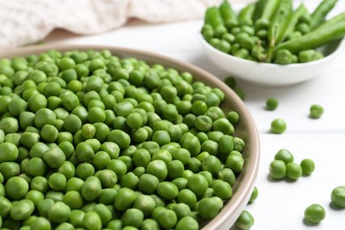 Photo of Fresh green peas and pods on white wooden table, closeup