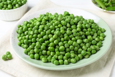 Fresh green peas and pods on white wooden table