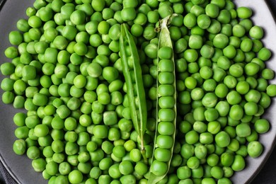 Photo of Fresh green peas and pods on black table, top view