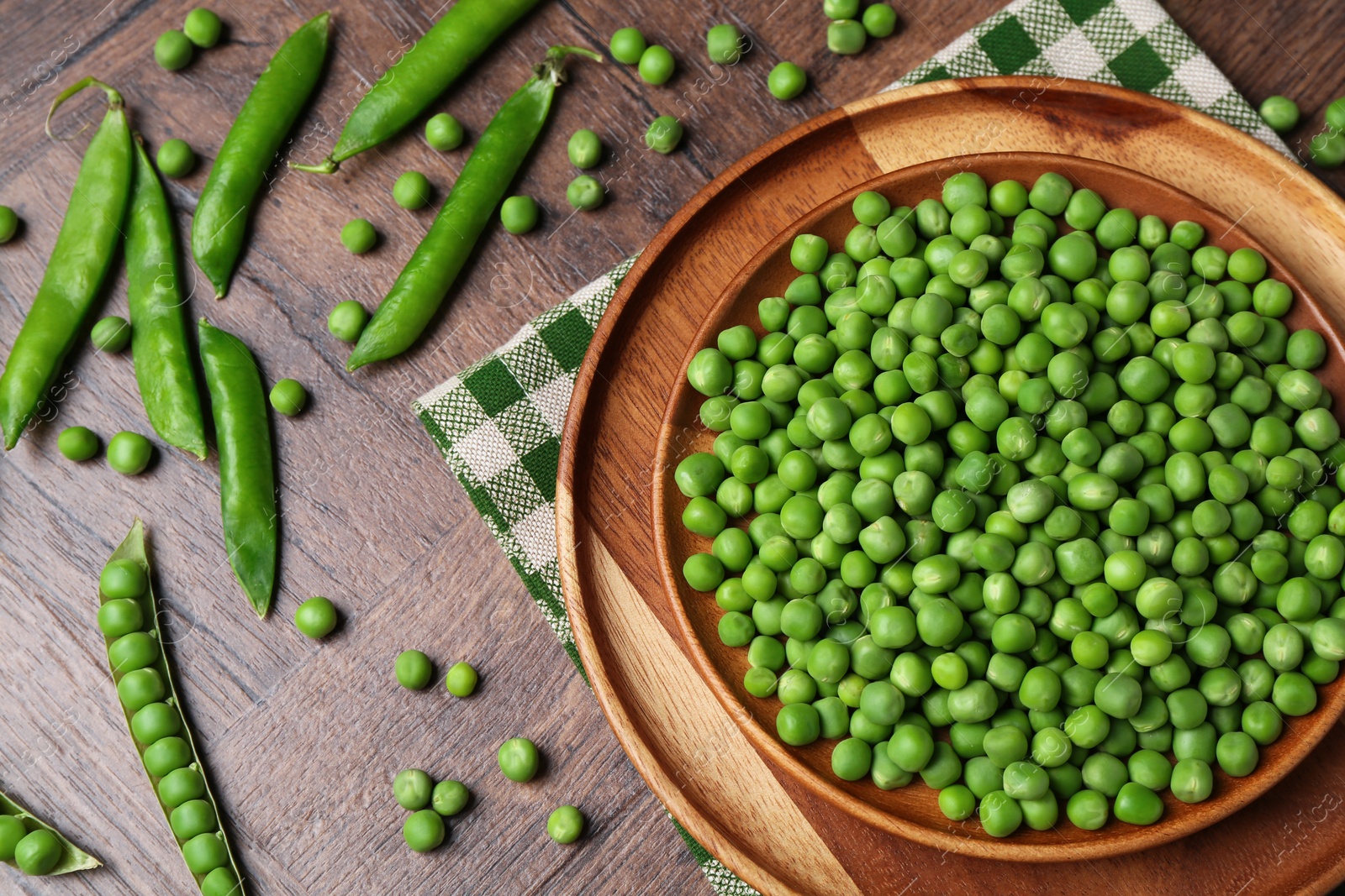 Photo of Fresh green peas and pods on wooden table, flat lay