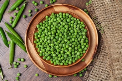 Photo of Fresh green peas and pods on wooden table, flat lay