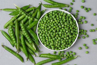 Photo of Fresh green peas and pods on grey table, flat lay