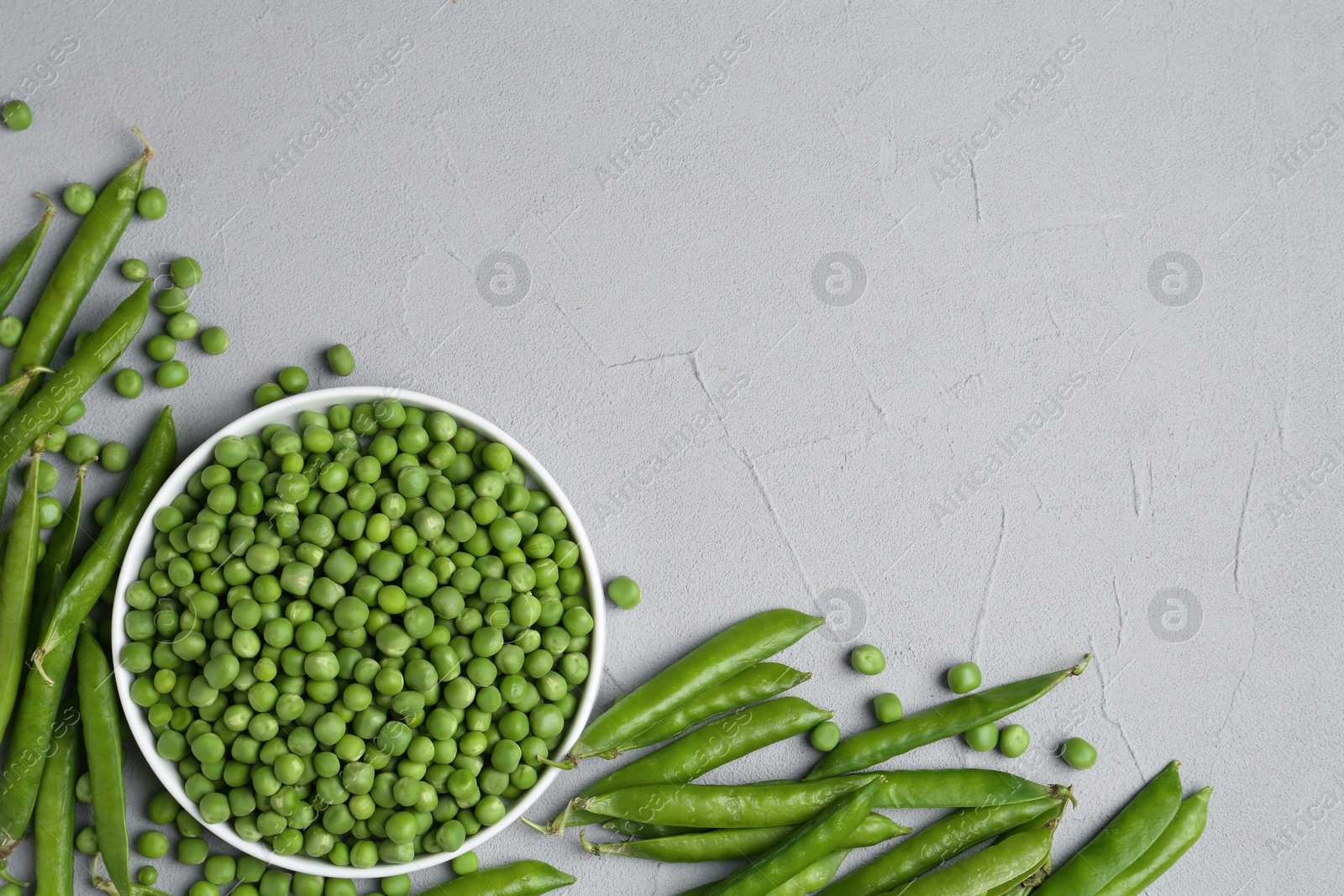 Photo of Fresh green peas and pods on grey table, flat lay. Space for text