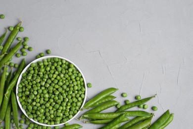 Photo of Fresh green peas and pods on grey table, flat lay. Space for text