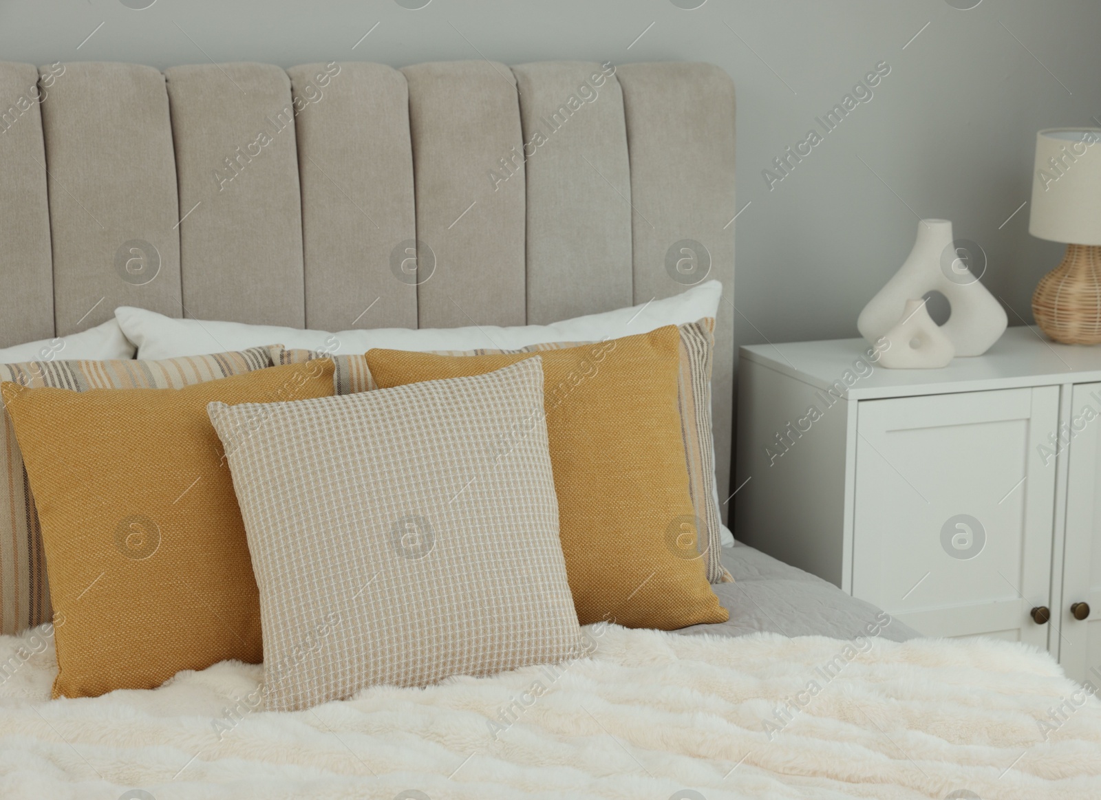 Photo of Different soft pillows on bed in room