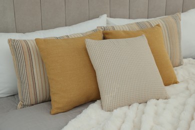 Photo of Different soft pillows on bed in room