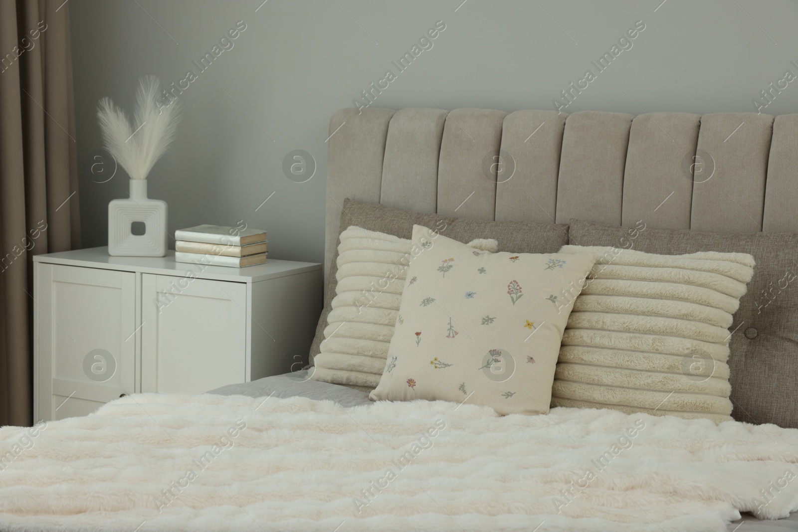 Photo of Different soft pillows on bed in room