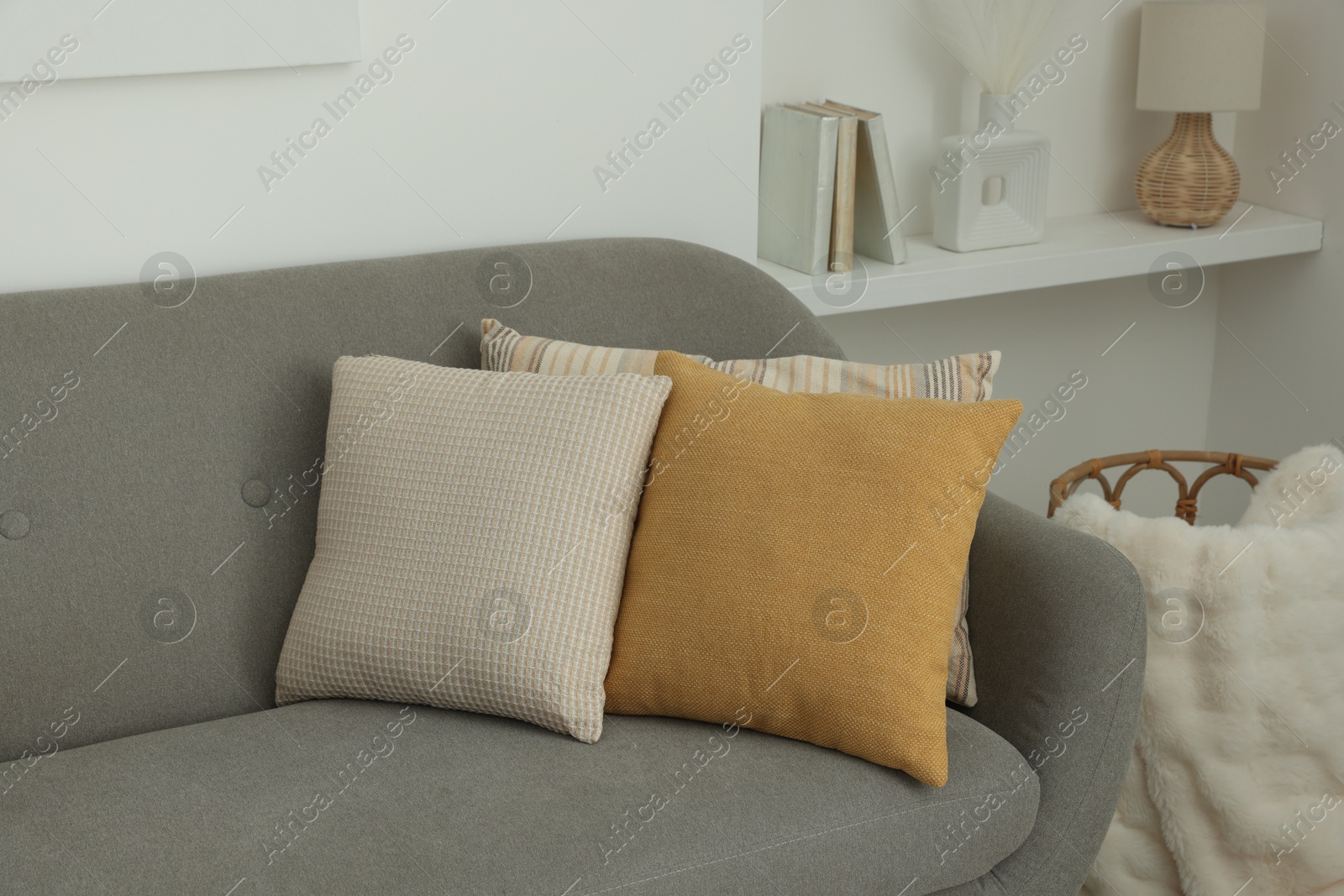 Photo of Different soft pillows on sofa in room