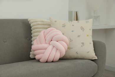 Different soft pillows on sofa in room