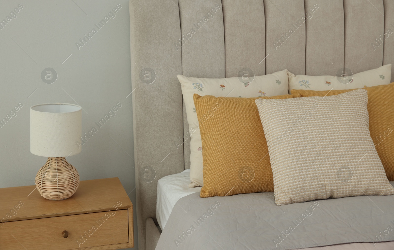 Photo of Different soft pillows on bed in room