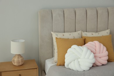 Photo of Different soft pillows on bed in room